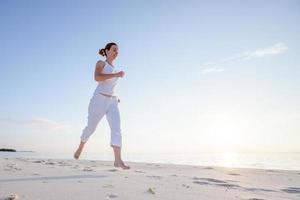 blanke vrouw joggen aan de kust foto