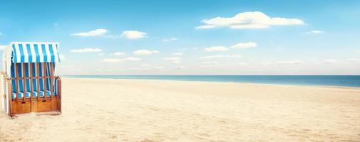 stormachtige Oostzee met strandstoelen en kustduinen. foto