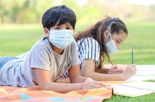 een half-Thaise-Indiase jongen en een gemengd-Thaise-Europese vriendin dragen gezichtsmaskers om virus te voorkomen foto