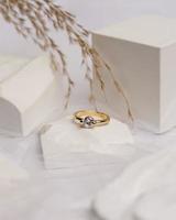 trouwring gezet op witte steen. de sieradenring is klaar om te worden tentoongesteld en verkocht. de trouwring is een teken van de liefde van het paar. parels en diamanten completeren de schoonheid van de ring. focus vervagen. foto