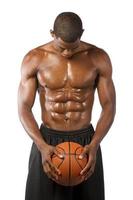 Afro-Amerikaanse man houdt basketbal naar beneden kijkt