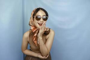 retro concept van een jonge Aziatische gelukkige vrouw lacht, geïsoleerd door een blauwe achtergrond foto