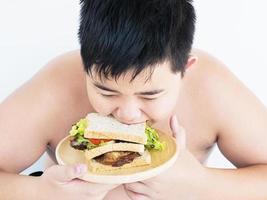 een jongen kijkt vrolijk naar sandwich. foto is gericht op sandwich.