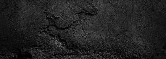 zwarte muur eng of donkergrijze ruwe korrelige steen textuur achtergrond. zwart beton voor achtergrond. foto