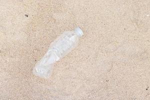 plastic flessen, afval op het zand foto