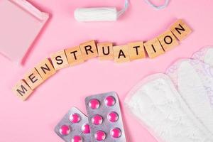 maandverband, tampons, pillen op roze achtergrond. producten voor vrouwelijke hygiëne voor menstruatie. foto