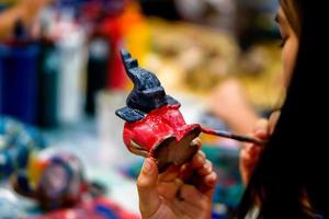 close-up handen van kunststudenten die penseelstudie houden en verf leren op houten dierenpop in het kunstklaslokaal. foto