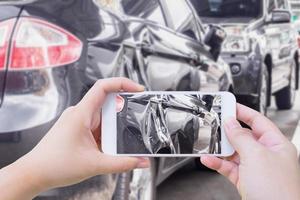vrouw die mobiele smartphone gebruikt en foto's maakt van het auto-ongeluk schade-ongeval foto