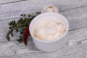 mayonaisesaus in de witte kom geserveerd met tijm en knoflook foto