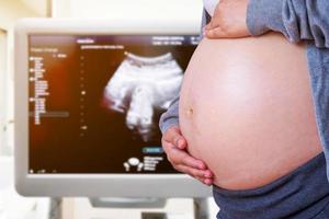 zwangere vrouw met echografie apparatuur achtergrond foto