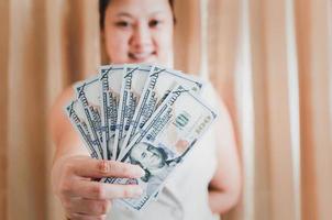 de rechterhand van een blanke vrouw die een mock-up bankbiljet van honderd dollar toont om te winkelen. selectieve aandacht. foto