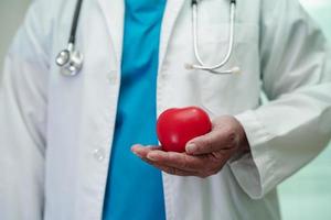 aziatische vrouw arts met rood hart voor gezondheid in het ziekenhuis. foto