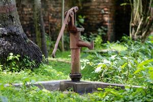 handbediende waterpomp, verroest en vergeten foto