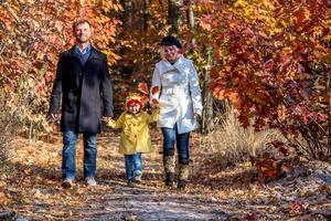 twee generatie familie wandelen in herfst bos vooraanzicht foto