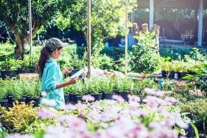 het meisje bestudeert en bewaart de verandering van bomen, bloemen mooie tuin bloem achtergrond in de natuur boeren foto