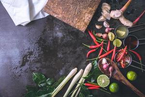 specerijen voor gebruik als kookingrediënten op een houten ondergrond met verse groenten. gezonde voeding kruiden. biologische groenten op tafel. grondstoffen van kookvoorbereiding tom yum. foto