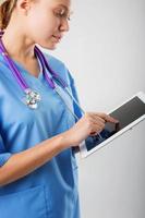 mooie jonge vrouwelijke medische stagiair met tablet-computer foto