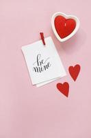 gelukkige Valentijnsdag samenstelling. lege wenskaart mockup, rode harten, confetti op roze achtergrond foto
