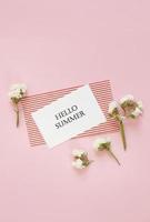 Hallo zomer. brieven zomer en bloemen op roze achtergrond. lege kaart met kopie ruimte. foto