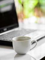 koffiekopje en laptop voor het bedrijfsleven, selectieve focus op koffie.