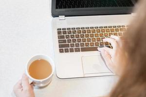 vrouw maakt gebruik van een laptop op de werkplek thuis foto