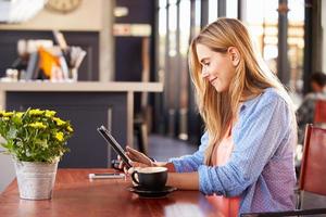 jonge vrouw met behulp van computer in een koffieshop foto