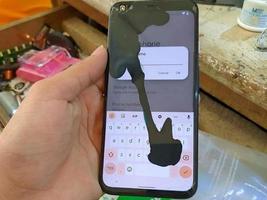 hand met gebroken mobiel scherm foto