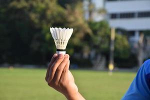 witte badmintonshuttle in de hand te houden. foto