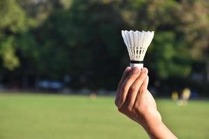 witte badmintonshuttle in de hand te houden. foto