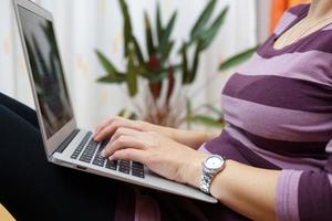 vrouw te typen op de laptop, vrouw thuis computer gebruikt foto