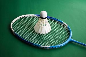 badminton sportuitrusting, shuttles, racket, grip, op de vloer van een indoor badmintonveld. foto