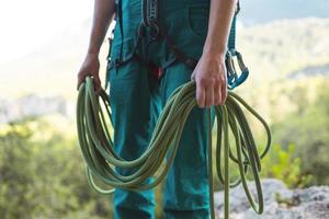een bergbeklimmer rolt een touw op foto