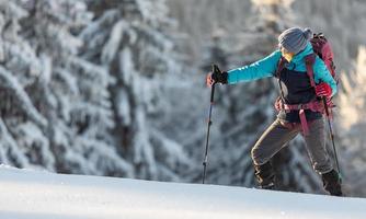 een wandelaar loopt op sneeuwschoenen in de sneeuw foto