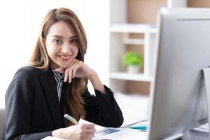 Aziatische zakenvrouw die op kantoor werkt met laptoppapierwerk, zakenvrouwconcept. foto