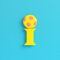 gele kolom met voetbal op helderblauwe achtergrond in pastelkleuren foto