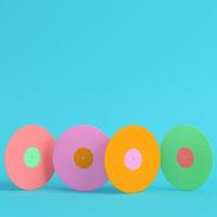 vier kleurrijke vinylplaten op helderblauwe achtergrond in pastelkleuren. minimalisme concept foto