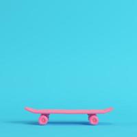 roze laag poly skateboard deck op felblauwe achtergrond in pastelkleuren foto