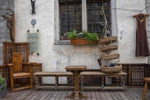 houten tafel gerangschikt door banken en stoel met mand hangend tegen raam foto