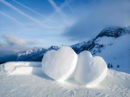 twee grote harten gemaakt van sneeuw in de prachtige bergen. foto