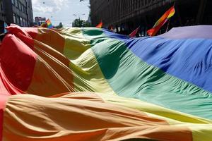 lgbtiq maart trots. kleurrijke parade ter ere van lgbtiq-rechten. demonstranten lopen met spandoeken en vlaggen. mensenrechten. trots, passie en protest. regenboog gezinnen. gelijkheid voor iedereen. foto