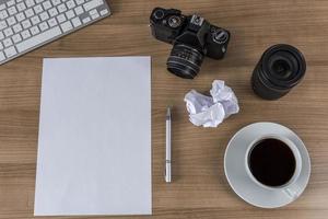 desktop met camera blanco vel en koffie foto