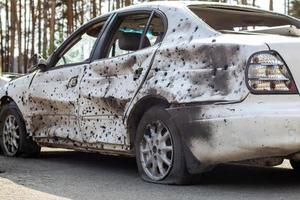 neergeschoten, beschadigde auto's tijdens de oorlog in oekraïne. het voertuig van burgers die zijn getroffen door de handen van het Russische leger. granaatscherven en kogelgaten in de carrosserie van de auto. Oekraïne, Irpen - 12 mei 2022. foto