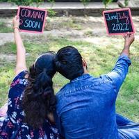 indiase paar poseren voor zwangerschaps baby shoot. het paar poseert in een gazon met groen gras en de vrouw pronkt met haar babybuil in de Lodhi-tuin in New Delhi, India foto