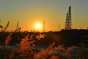 bouwplaats en elektrische paal met zonsopganghemel foto