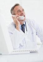 glimlachende arts die een oproep beantwoordt foto