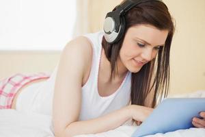 lachende meisje, luisteren naar muziek op tablet pc foto