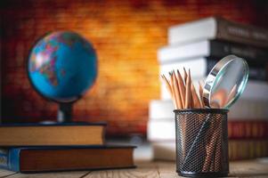 leerboeken, globe en potloden op een houten achtergrond. educatieve achtergrond foto