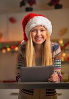 portret van tiener meisje in kerstmuts met behulp van tablet pc