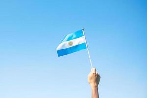 hand met de vlag van Argentinië op de achtergrond van de natuur. 9 juli van onafhankelijkheidsdag, 25 mei van revolutiedag en gelukkige vieringsconcepten foto