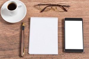 notebook met pen, smartphone en koffiekopje